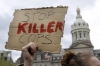 A protestor holds a sign outside of Baltimore’s City Hall before a march for Freddie Gray, Thursday, April 23, 2015, in Baltimore. Gray died from spinal injuries about a week after he was arrested and transported in a police van. 