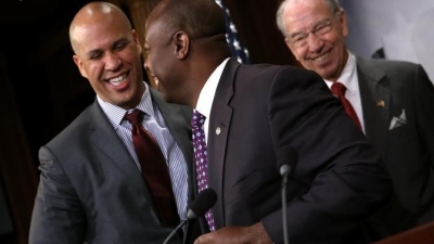 Sen. Cory Booker (D-N.J.) greets Sen. Tim Scott (R-S.C.) as Senate Judiciary Committee Chairman Sen. Chuck Grassley (R-Iowa) looks on during a press conference Oct. 1, 2015, at the U.S. Capitol announcing a bipartisan effort to reform the criminal-justice system.  